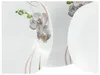 A close-up view of several white plates with an orchid design. Produktbild-Vorschau