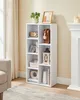 A white bookshelf filled with decorative items and books, placed in a room next to a fireplace.