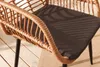 Close-up of a wicker chair with a dark cushion, placed on a wooden deck. Produktbild-Vorschau