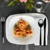 A table setting with a bowl of tortellini, cutlery, and a glass of water, with flowers in the background. Voir les images du produit
