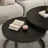 Two round coffee tables stacked on a rug, with a book and a decorative object on the lower table, and a book and a vase with reeds on the upper table. Náhľad obrázku produktu