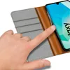 A hand is shown interacting with a phone case that is open, revealing the phone screen. Náhled obrázku produktu