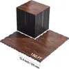 A stack of interlocking floor tiles with a wood grain pattern, with a few tiles laid out on the floor. Voir les images du produit