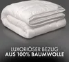 A folded white duvet is presented against a dark gray background, with text overlay describing its material. Produktbild-Vorschau