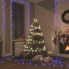 A decorated Christmas tree with gifts underneath, in a room with Christmas lights. Náhľad obrázku produktu