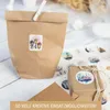 A brown paper bag with a sticker on it, and a small gift box with a sticker on it, on a wooden surface. Produktbild-Vorschau