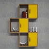 A modular wall shelf unit with yellow cabinet doors and brown wood accents, mounted on a textured gray wall. Produktbild-Vorschau