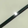 A close-up shot of a dark green and black striped object with a bright white light on it, set against a light gray background. Voir les images du produit