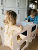 Two young children are sitting at a wooden learning tower, drawing on paper. Anteprima dell’immagine prodotto