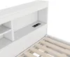 Close-up view of a white bed frame with a built-in headboard shelf and integrated power outlets. Náhled obrázku produktu