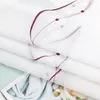 A close-up view of folded white fabric with a delicate embroidered pattern. Produktbild-Vorschau