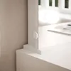 A close-up view of a white vanity or dressing table with a mirror and a small white knob on the side. Produktbild-Vorschau