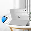 A clear case for an iPad is shown standing upright on a table, with its cover folded to act as a stand. Produktbild-Vorschau
