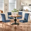 A dining set with four blue upholstered chairs around a round wooden table in a kitchen. Produktbild-Vorschau