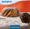A marble cake and a chocolate muffin are dusted with powdered sugar on a surface covered in flour, with an orange background. Produktbild-Vorschau