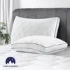 Two white pillows with blue trim are displayed on a white mattress. Produktbild-Vorschau