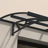A close-up view of a black and clear door awning attached to a light-colored wall. Podgląd zdjęcia produktu