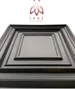 A close-up, angled view of a dark gray, multi-layered square panel, likely a wall or ceiling tile, with a logo and text above it. Náhled obrázku produktu