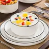 A table setting with a bowl of fruit and yogurt, plates, and cutlery. Produktbild-Vorschau