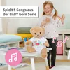 A young girl is dancing next to a teddy bear sitting on a small table. There are musical notes around the teddy bear and a text overlay. Anteprima dell’immagine prodotto