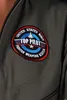 A close-up of a patch on a gray garment. Produktbild-Vorschau