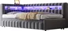 A gray upholstered bed with built-in LED lighting and storage shelves in the headboard. Náhled obrázku produktu