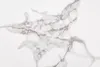 A close-up view of a white surface with gray veining, resembling marble or ceramic. Produktbild-Vorschau