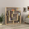 A modern wooden bookshelf is placed against a light gray wall, with a sofa and framed pictures visible in the background. Podgląd zdjęcia produktu