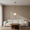 A modern living room with a white sofa, a wooden coffee table, and a gold pendant light. Náhľad obrázku produktu
