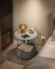 A bedside table next to a bed, with a lamp, tablet, and alarm clock on top. Náhled obrázku produktu