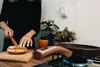 A person is preparing food in a kitchen, with a gas detector mounted on the wall. Podgląd zdjęcia produktu