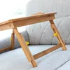A close-up shot of a wooden lap desk with yellow adjustable knobs, resting on a light gray sofa. Produktbild-Vorschau
