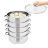 A multi-tiered stainless steel steamer with a glass lid and a hand holding the lid's handle. Podgląd zdjęcia produktu