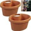 Two brown planters are shown against a white background, with a small inset image showing planters mounted on a brick wall with flowers. Produktbild-Vorschau