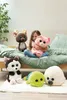 A young girl is sitting on a bed with several stuffed animals around her. Produktbild-Vorschau