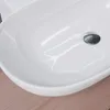 A close-up view of a white ceramic sink with a chrome drain. Produktbild-Vorschau