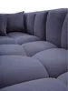 A close-up view of a blue sectional sofa with plush cushions and a tufted design. Náhled obrázku produktu