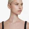 A woman wearing a necklace and earrings. Produktbild-Vorschau