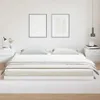 A minimalist bedroom scene featuring a white bed frame with a mattress and bedding. Náhled obrázku produktu