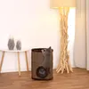 A cat climbing on a cat scratching tower next to a table with vases and a floor lamp. Podgląd zdjęcia produktu