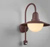 A close-up shot of a brown outdoor wall light mounted on a light gray wall. Produktbild-Vorschau