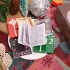 A collection of miniature books arranged on a festive, patterned surface, suggesting a holiday or advent theme. Náhled obrázku produktu