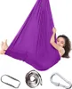 A young girl is playing in a purple therapy swing. Náhled obrázku produktu