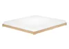 A white mattress on a low wooden bed frame against a white background. Produktbild-Vorschau