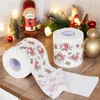 Christmas-themed toilet paper rolls are displayed on a countertop with festive decorations in the background. Náhľad obrázku produktu