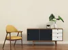 A yellow chair and a black and white cabinet are placed against a light beige wall. Produktbild-Vorschau