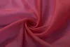 A close-up, swirled view of bordeaux-colored sheer fabric. Produktbild-Vorschau