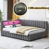 A grey upholstered bed with a built-in headboard shelf featuring pink LED lighting, a tablet, and decorative items. A close-up inset shows USB charging ports. Náhled obrázku produktu
