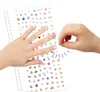 A child's hand is shown applying stickers to their fingernails from a sheet of stickers. Anteprima dell’immagine prodotto