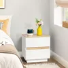 A bedside table with a mug and flowers next to a bed. Produktbild-Vorschau